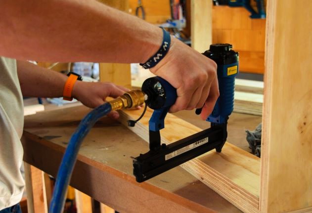 Carpintero perforando una madera con su herramienta para montar un mueble.