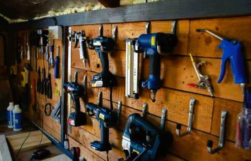 herramientas de carpintero colgadas en una pared de madera